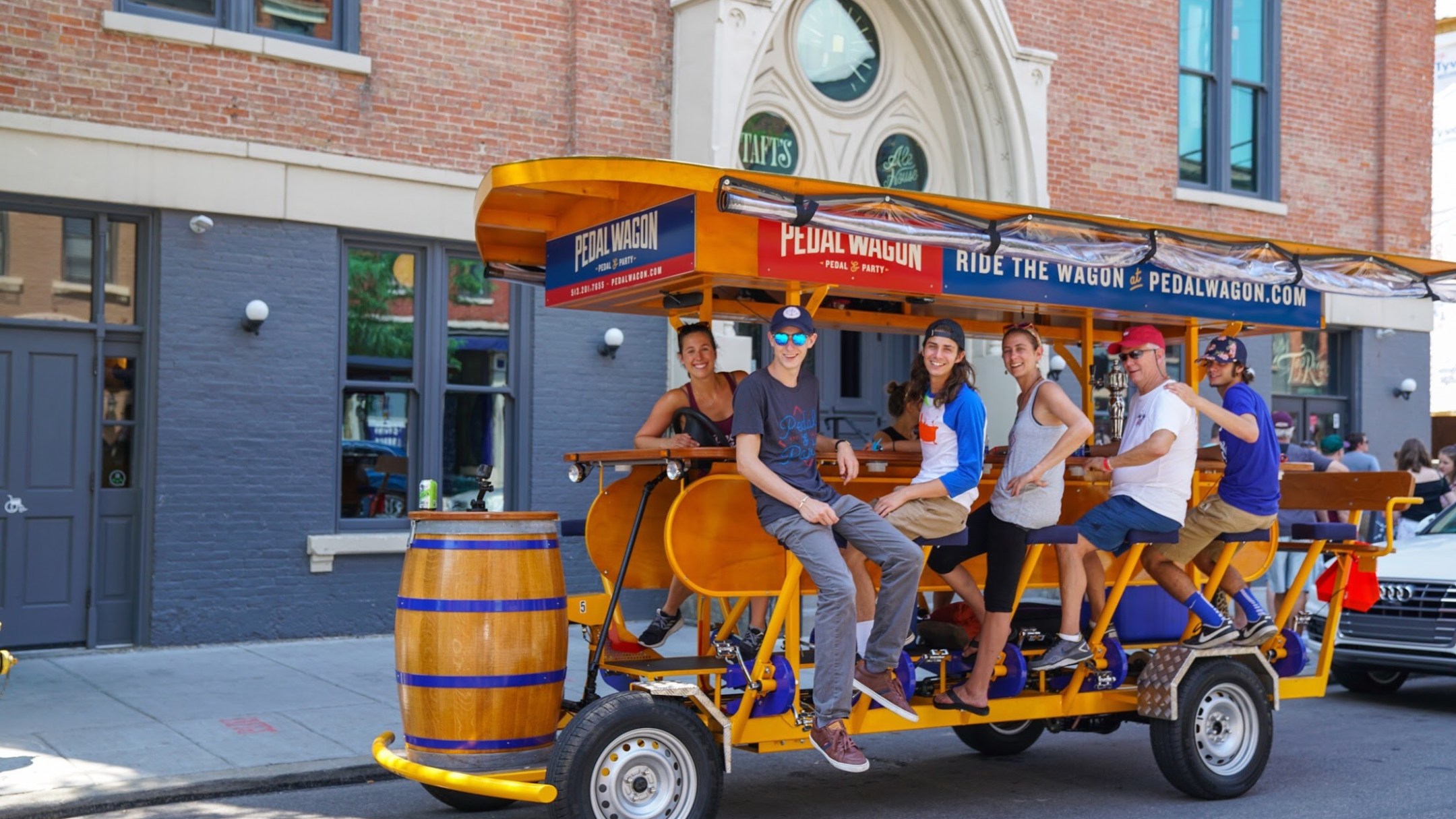 group of people and guide on pedal wagon