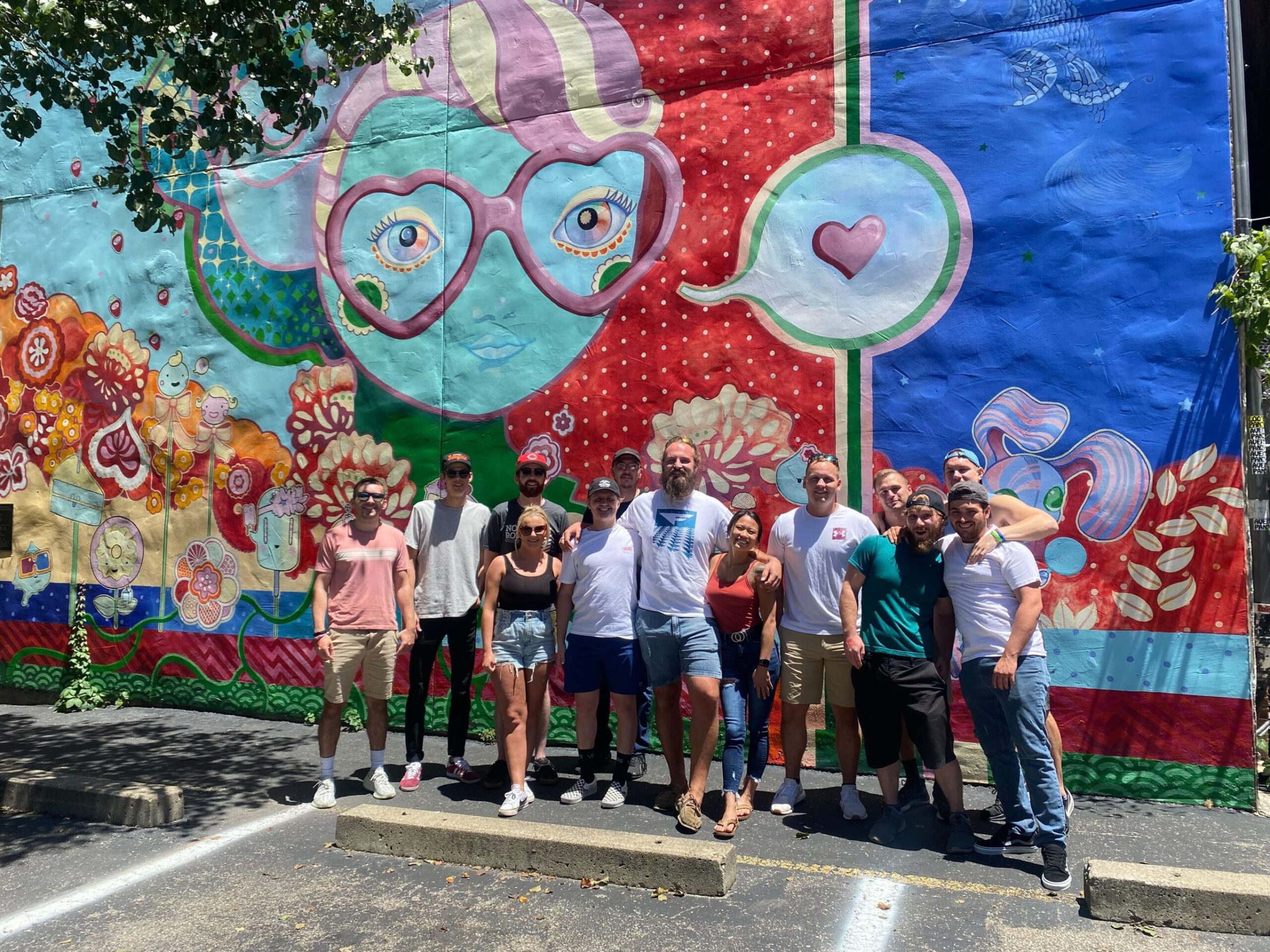 a group of people standing in front of a graffiti wall