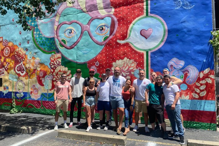 a group of people standing in front of a graffiti wall