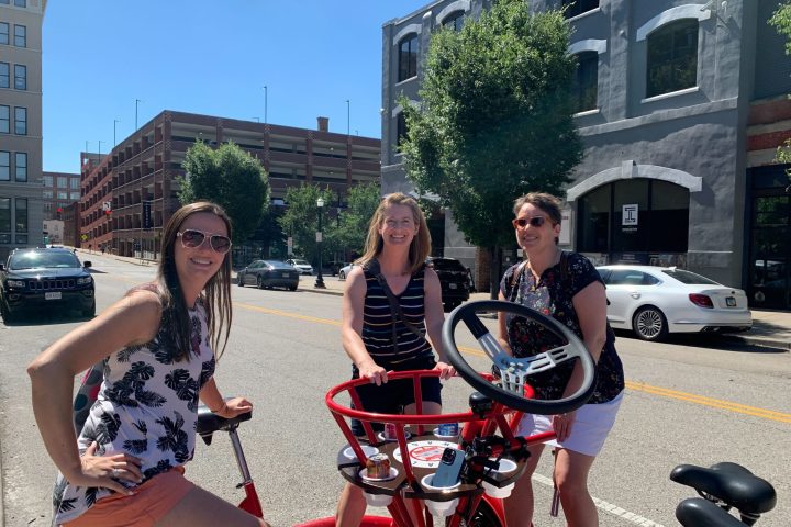 a group of people sitting on a motorcycle in front of a building