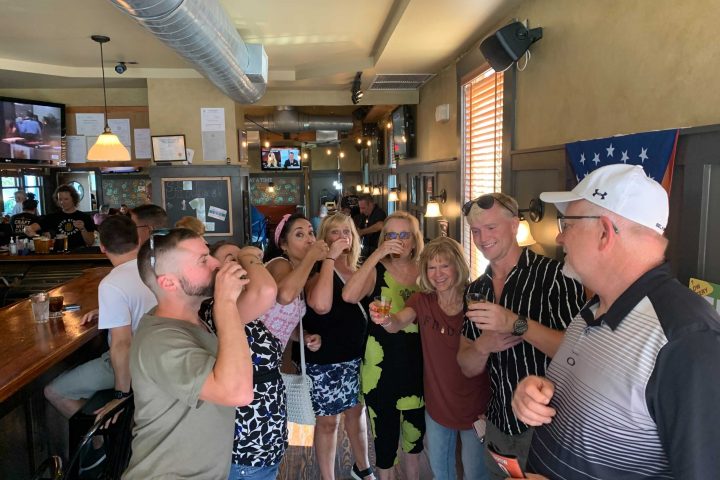 a group of people are drinking from a wine glass posing for the camera