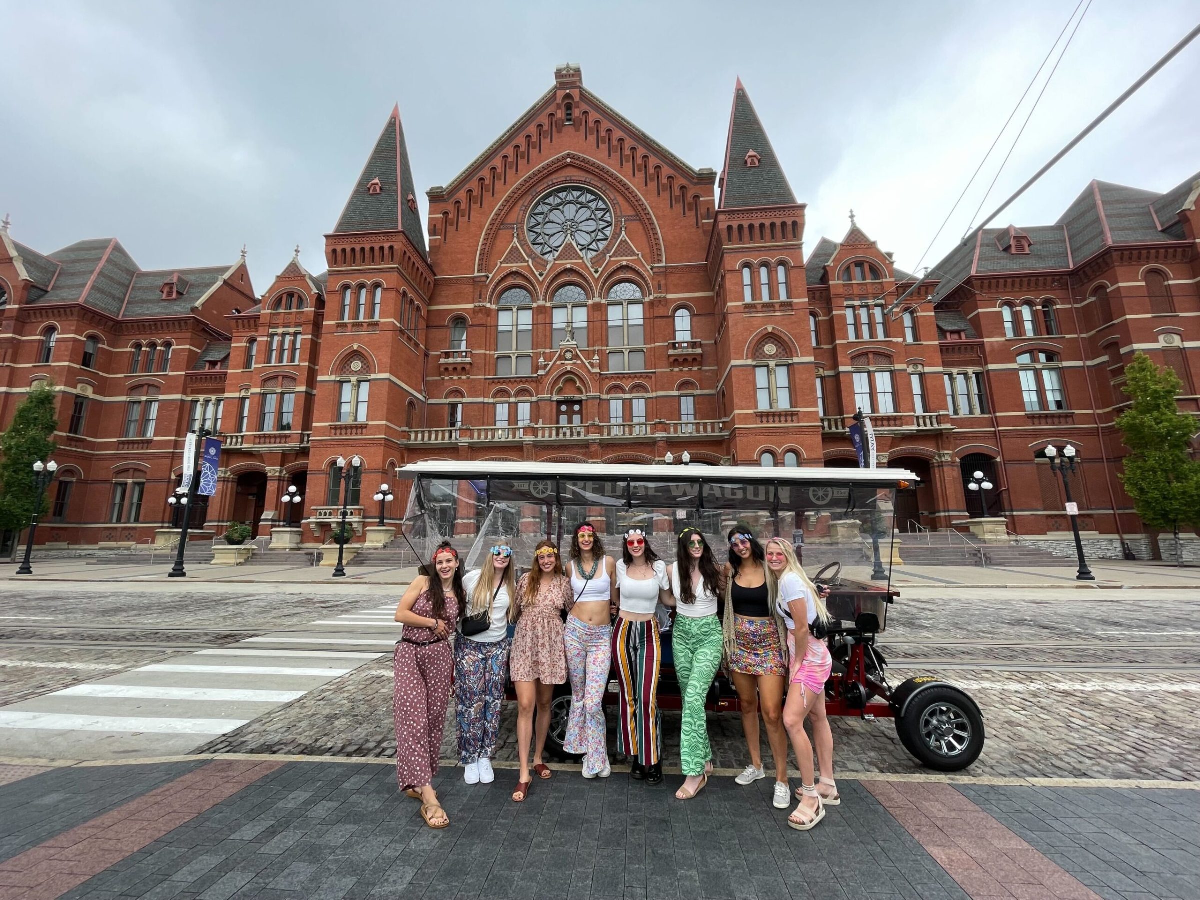 a group of people walking in front of Cincinnati Music Hall