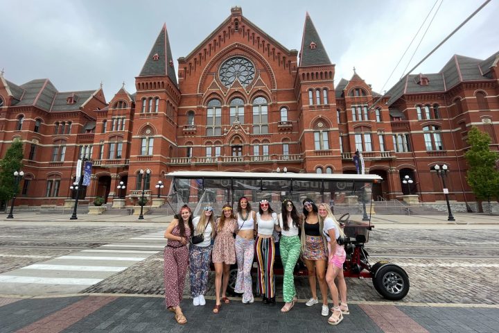 a group of people walking in front of Cincinnati Music Hall